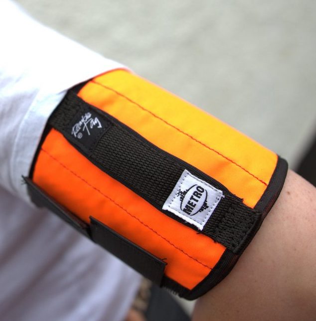 The orange metro tag with the flat handle worn on the upper arm.