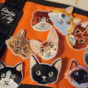 A selection of little cat head patches to sew on your ramble tag. They vary in colour, each picture will have alt text to describe further.